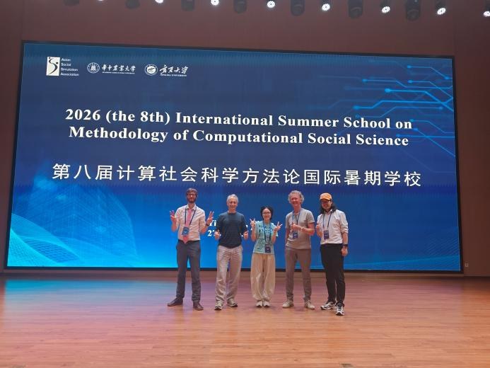 计算社会科学暑期学校背景屏幕前的五人合影
